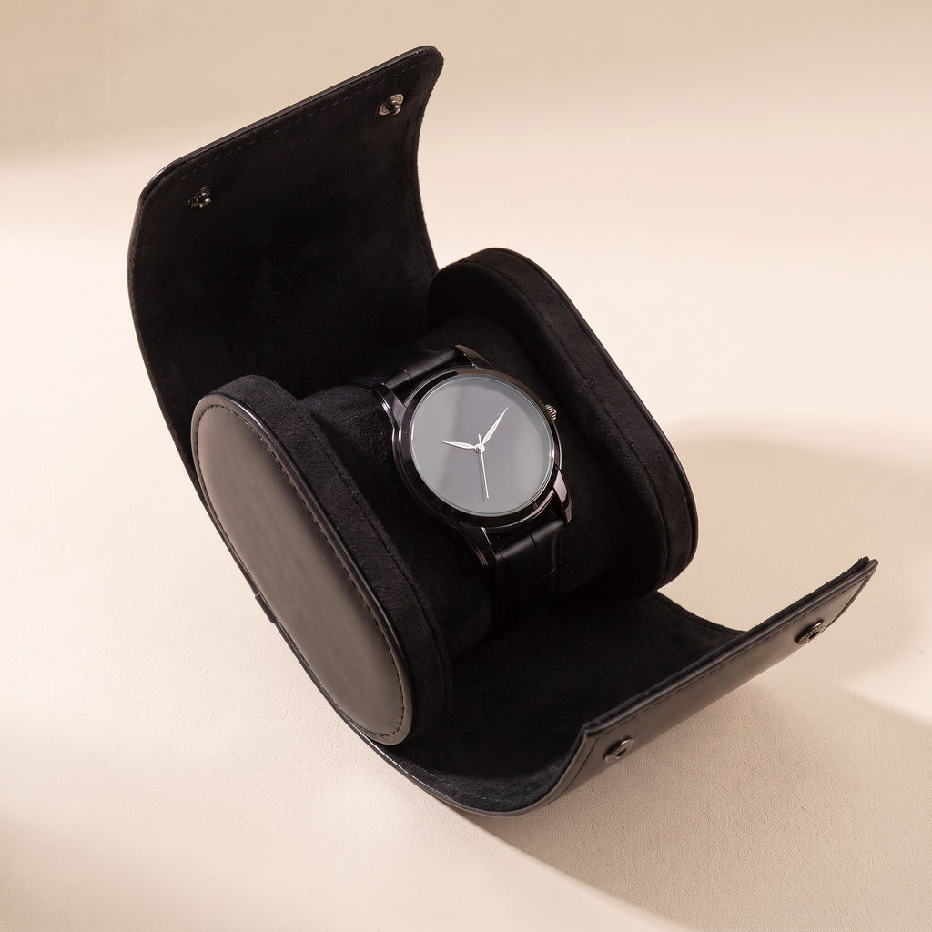 Étui de voyage Escale noir ouvert, avec une montre sur son coussin intérieur
