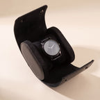 Étui de voyage Escale noir ouvert, avec une montre sur son coussin intérieur