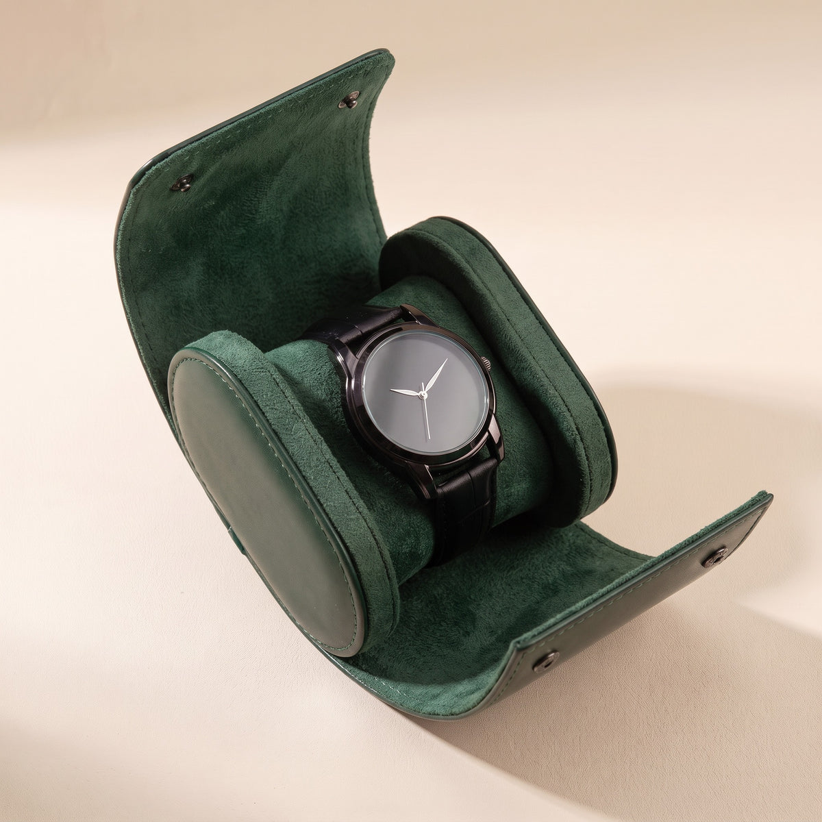 Étui de voyage Escale vert foncé ouvert, avec une montre sur son coussin intérieur